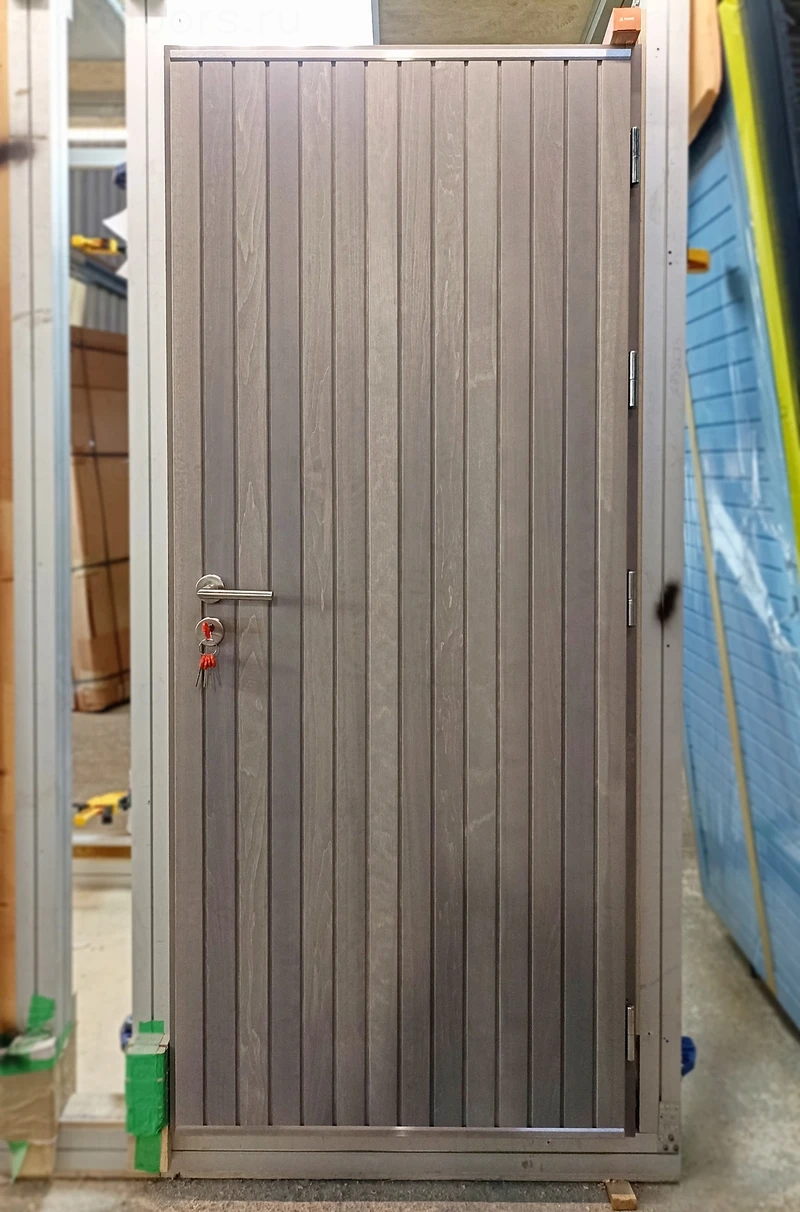 Морозостойкие двери с отделкой планками из массива дерева Scandoors Planken с утепленным дверным полотном толщиной 96мм в исполнении Thermo (2 контура уплотнения) или Arctic (3 контура уплотнителей+дополнительное усиление полотна). Расположение планок может быть как вертикальное так и горизонтальное. В базовой комплектации замок DIN стандарта пр–ва Германия и фурнитура из нержавеющей стали; доступные дополнительные опции: трехточечный многозапорный замок, замок и фурнитура Abloy скандинавского типа, скрытые петли, отделка из термообработанной древесины. – фото Scandoors